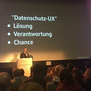 The author on a stage, with a slide: 'Datenschutz-UX: Lösung, Verantwortung, Chance'
