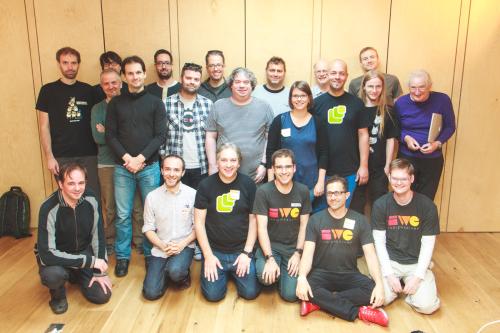 A group of two dozen participants, some with IWC t-shirts and name tags