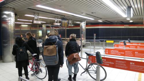 A group of five young people with two bicycles, entering the Hakaniemi subway station in Helsinki