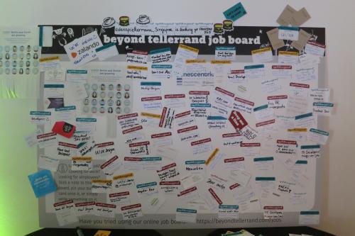 A whiteboard covered with stickers of people searching for staff or jobs