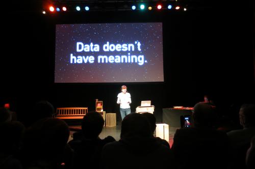 Erika on stage with a slide saying 'Data doesn't have meaning'